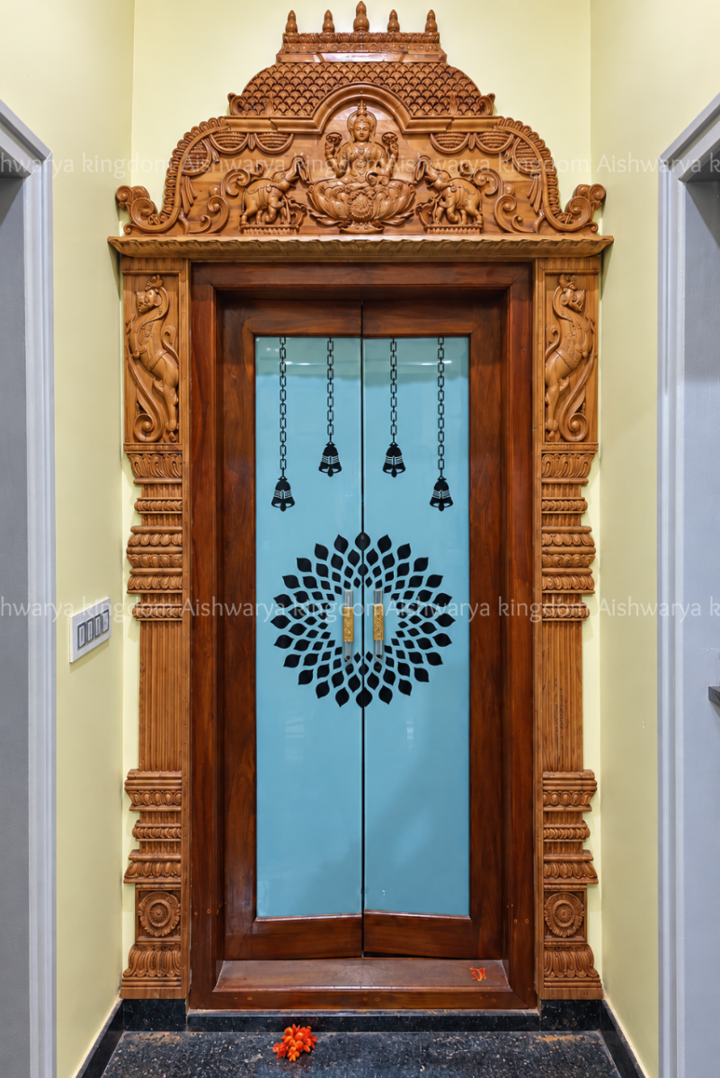 Wooden pooja room door with carved Gajalakshmi frame and temple top
